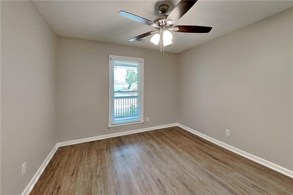 3883 Nowlin Road Kennesaw, GA 30144 - Photo 15 of 21 an empty room with wooden floor chandelier fan and window