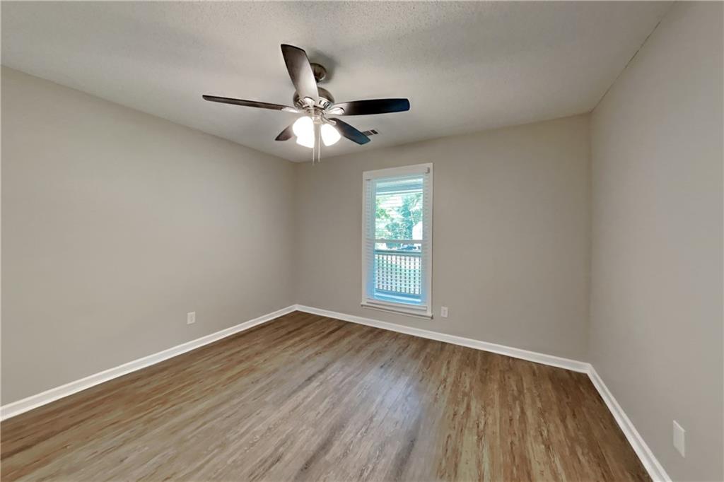 3883 Nowlin Road Kennesaw, GA 30144 - Photo 17 of 21 an empty room with wooden floor fan and windows