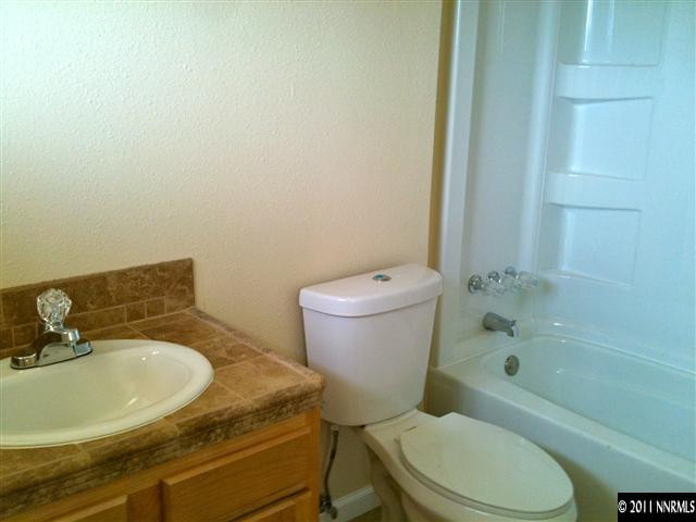 10305 Wells Fargo Road Reno, NV 89508 - Photo 4 of 6 a white toilet sitting next to a bathroom sink and tub