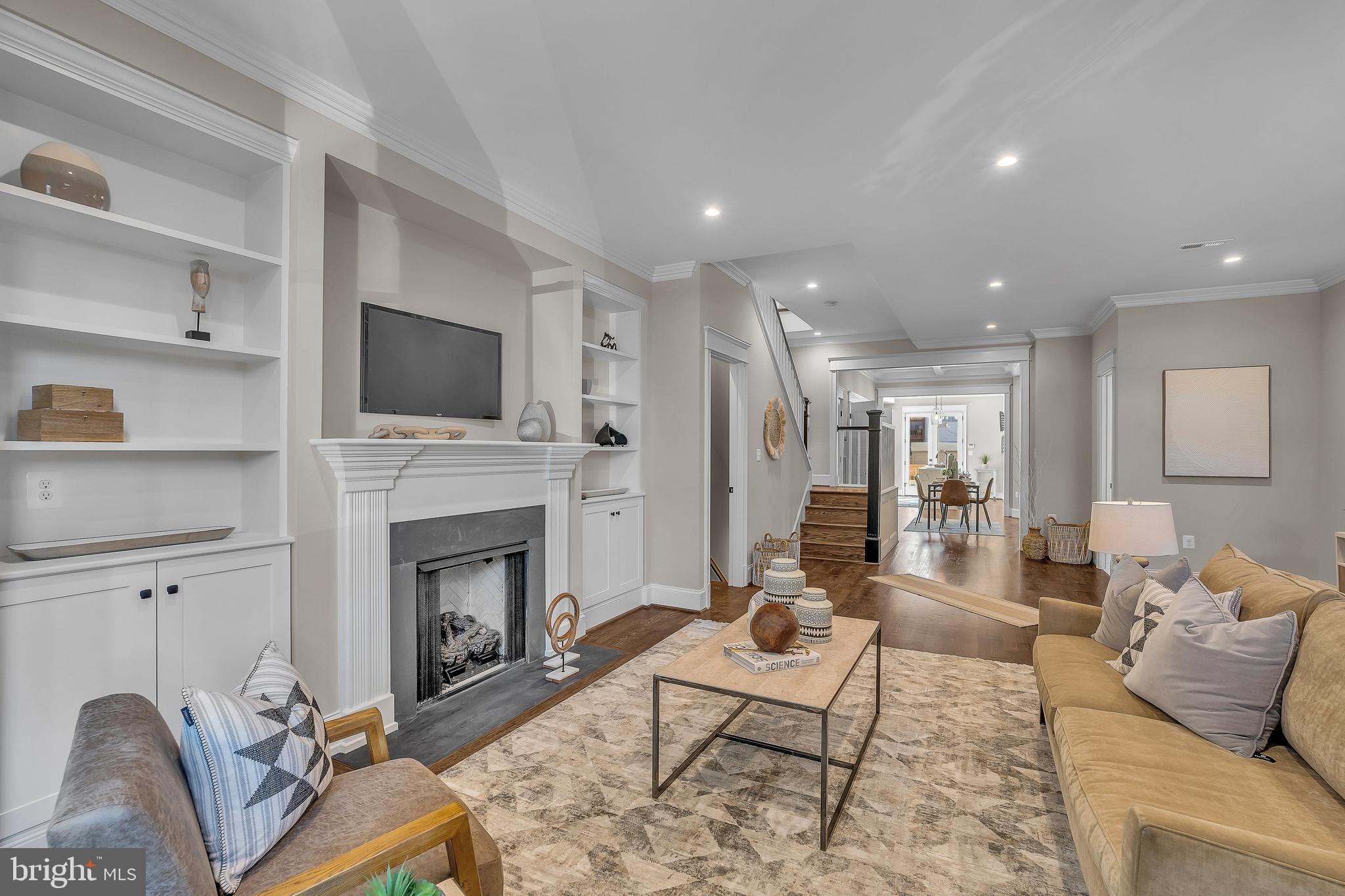 a living room with furniture a fireplace and a flat screen tv