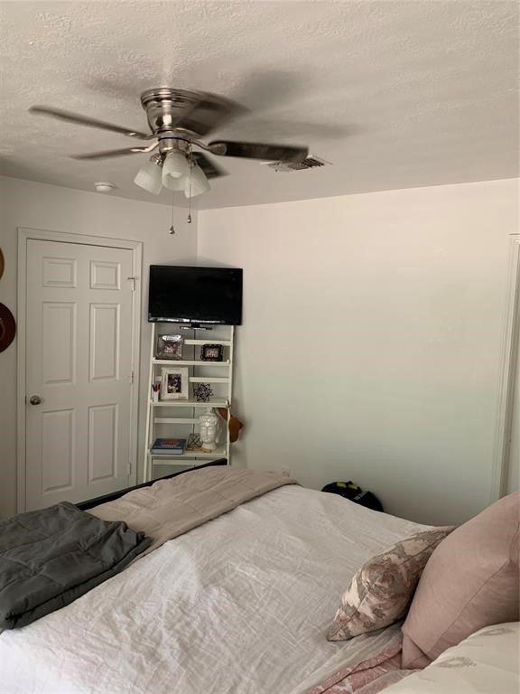 2904 Old Houston Road, Unit 7 Huntsville, TX 77340 - Photo 18 of 19 a bedroom with a bed and a flat tv screen on a dresser