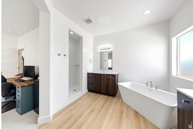5963 Flattop Drive St. George, UT 84790 - Photo 23 of 45 Spacious bathroom featuring a freestanding tub, separate shower enclosure, wood-finish flooring, and a vanity with a quartz countertop