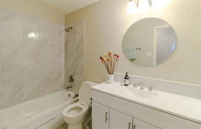 a bathroom with a sink mirror and toilet