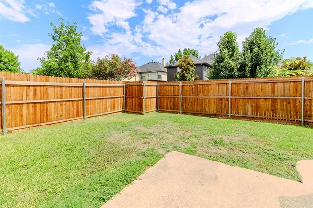 a view of a backyard with wooden fence