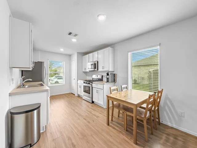 a kitchen with a dining table chairs stove and refrigerator
