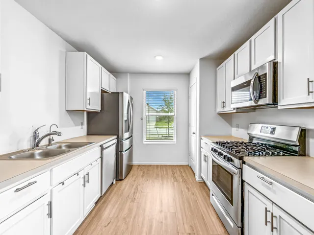 a kitchen with stainless steel appliances granite countertop a sink stove and refrigerator