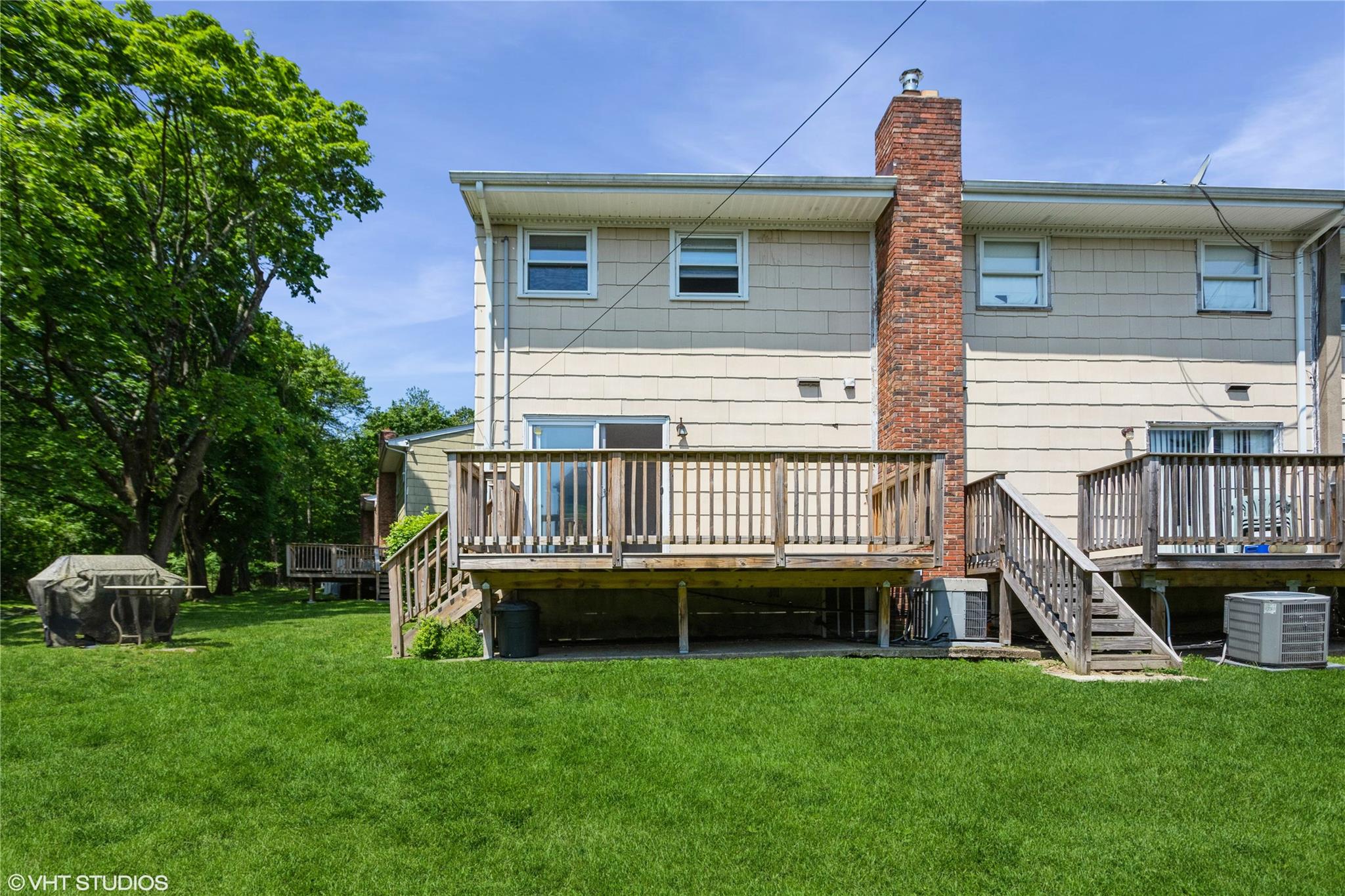 15 Sharon Drive Spring Valley, NY 10977 - Photo 17 of 24 Rear view of house with a chimney, a deck, a lawn, and central AC