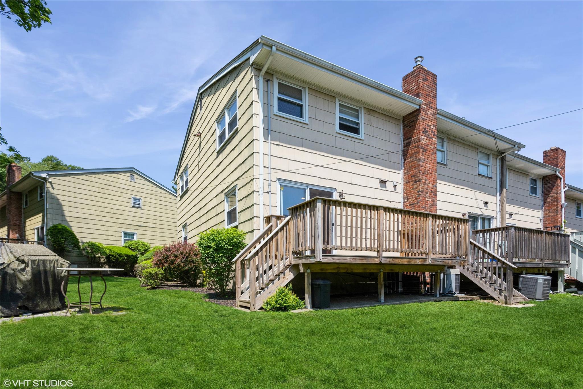 15 Sharon Drive Spring Valley, NY 10977 - Photo 18 of 24 Back of house featuring stairway, a chimney, a wooden deck, and a lawn