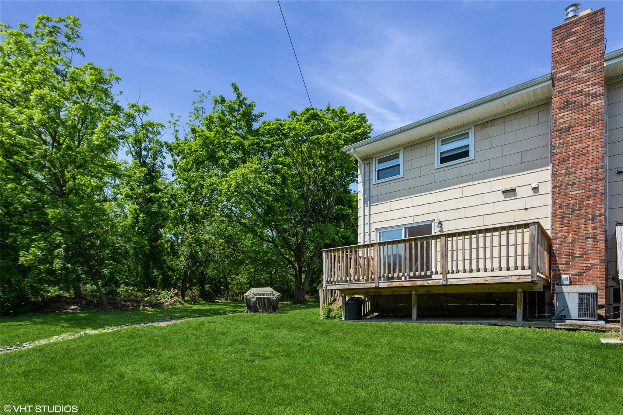 15 Sharon Drive Spring Valley, NY 10977 - Photo 19 of 24 Rear view of house featuring a wooden deck, central air condition unit, a lawn, and a chimney