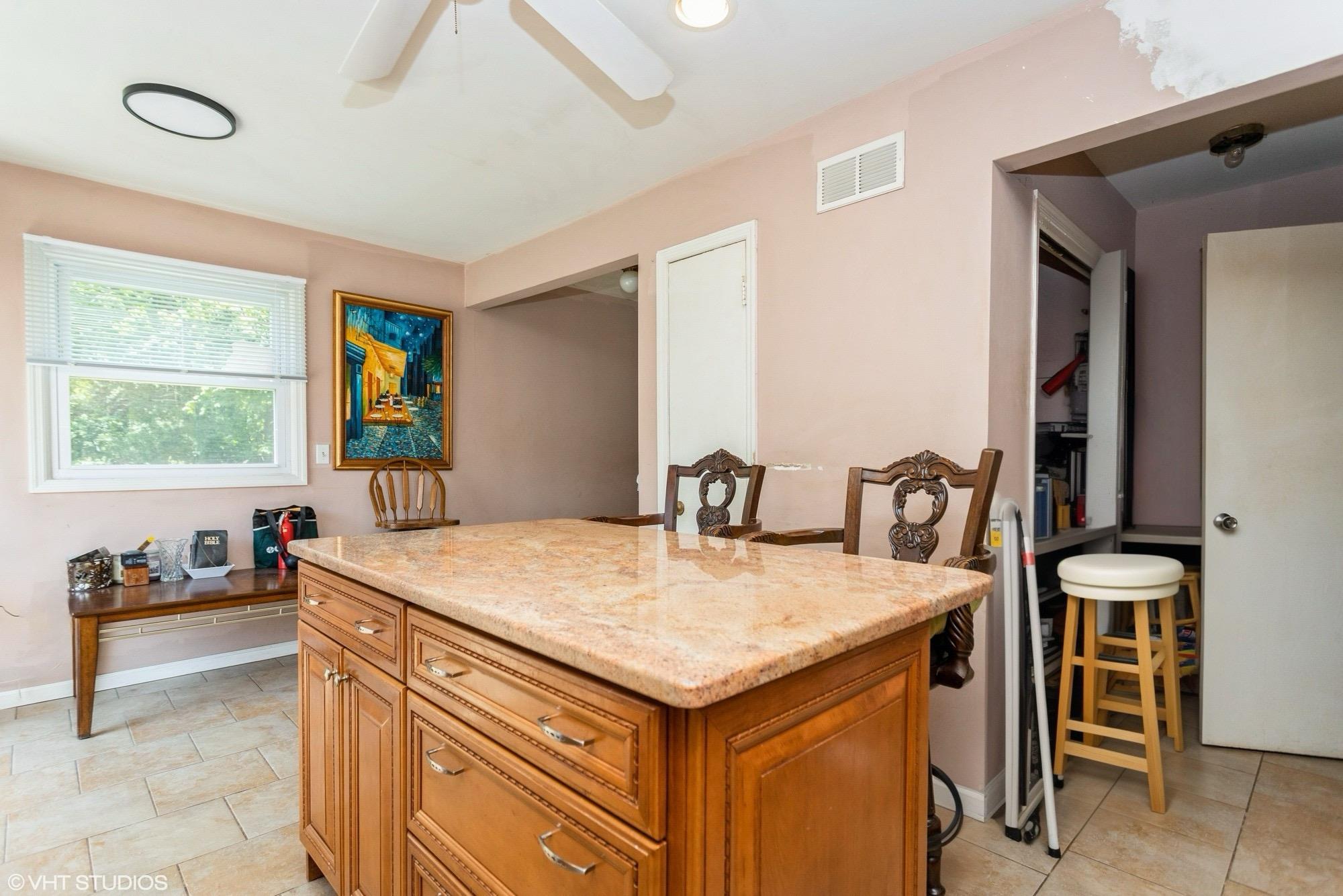 15 Sharon Drive Spring Valley, NY 10977 - Photo 6 of 24 Kitchen featuring brown cabinets, ceiling fan, a kitchen island, light stone counters, and baseboards