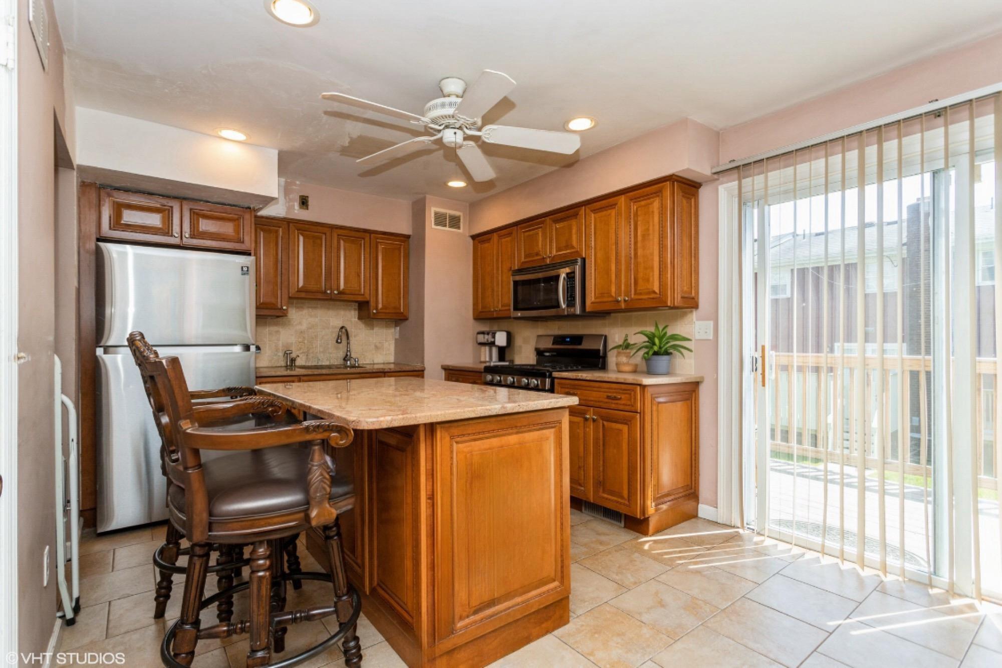 15 Sharon Drive Spring Valley, NY 10977 - Photo 8 of 24 Kitchen featuring appliances with stainless steel finishes, brown cabinets, tasteful backsplash, a ceiling fan, and a sink