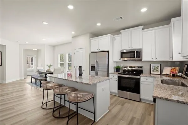 a kitchen with stainless steel appliances granite countertop a refrigerator stove microwave and cabinets
