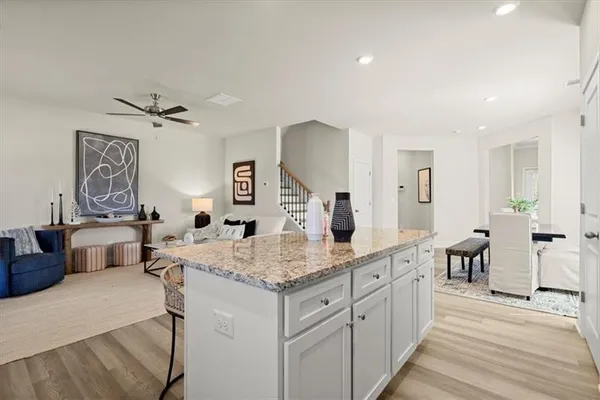 a open kitchen with stainless steel appliances granite countertop a sink dishwasher and a dining table with wooden floor