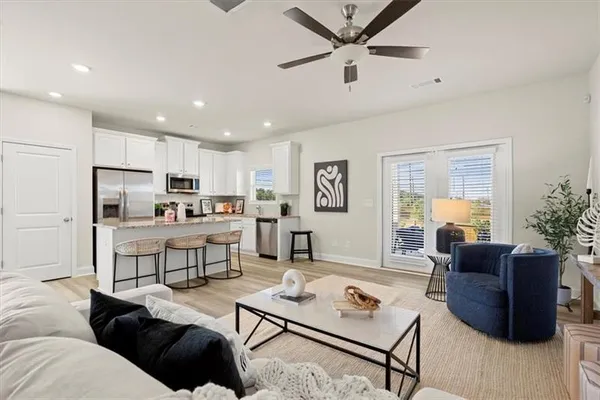 a living room with furniture kitchen view and a refrigerator