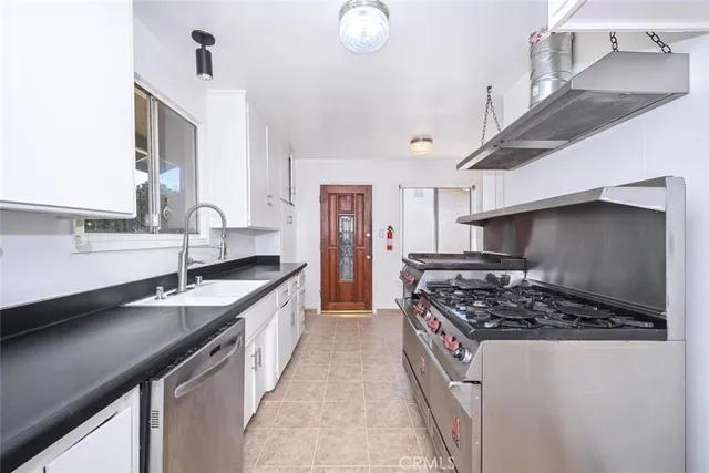 a kitchen with granite countertop white cabinets white stainless steel appliances and sink