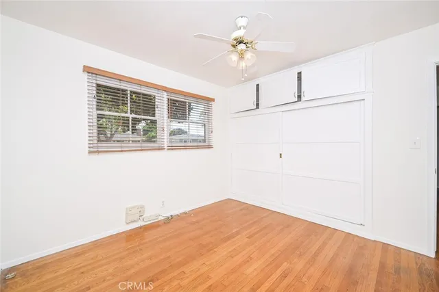 an empty room with a window and a fan