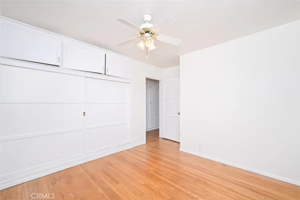 an empty room with a window and a fan