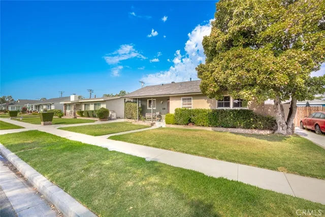 a view of a house with a big yard and large trees