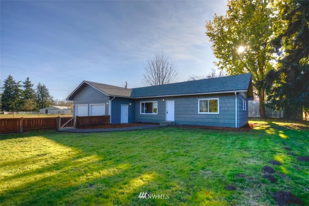 8231 James Road Southwest Rochester, WA 98579 - Photo 2 of 25 a backyard of a house with wooden floor table and chairs