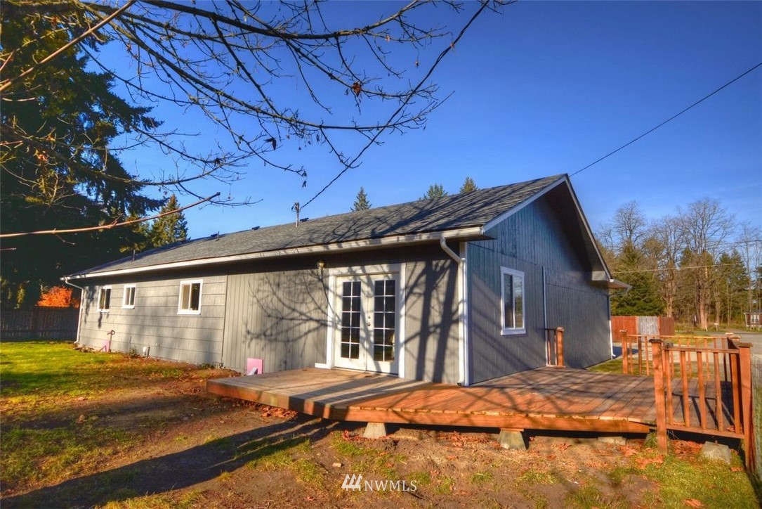 8231 James Road Southwest Rochester, WA 98579 - Photo 23 of 25 a backyard of a house with large trees and wooden fence