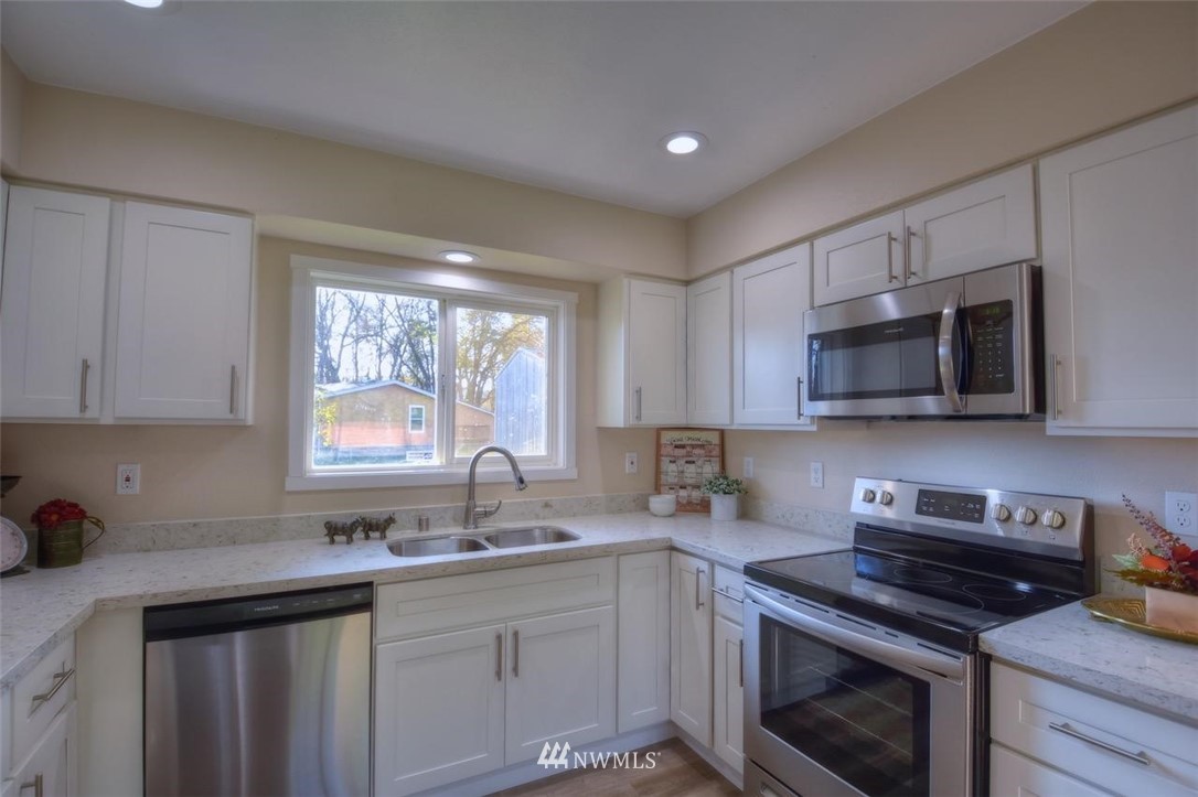 8231 James Road Southwest Rochester, WA 98579 - Photo 7 of 25 a kitchen with stainless steel appliances a sink a stove a microwave and cabinets