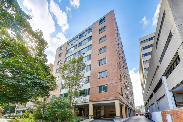 a front view of a multi story building with a yard