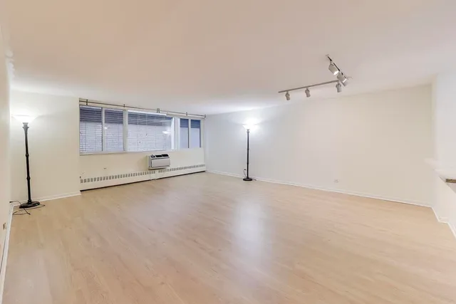 an empty room with closet and windows