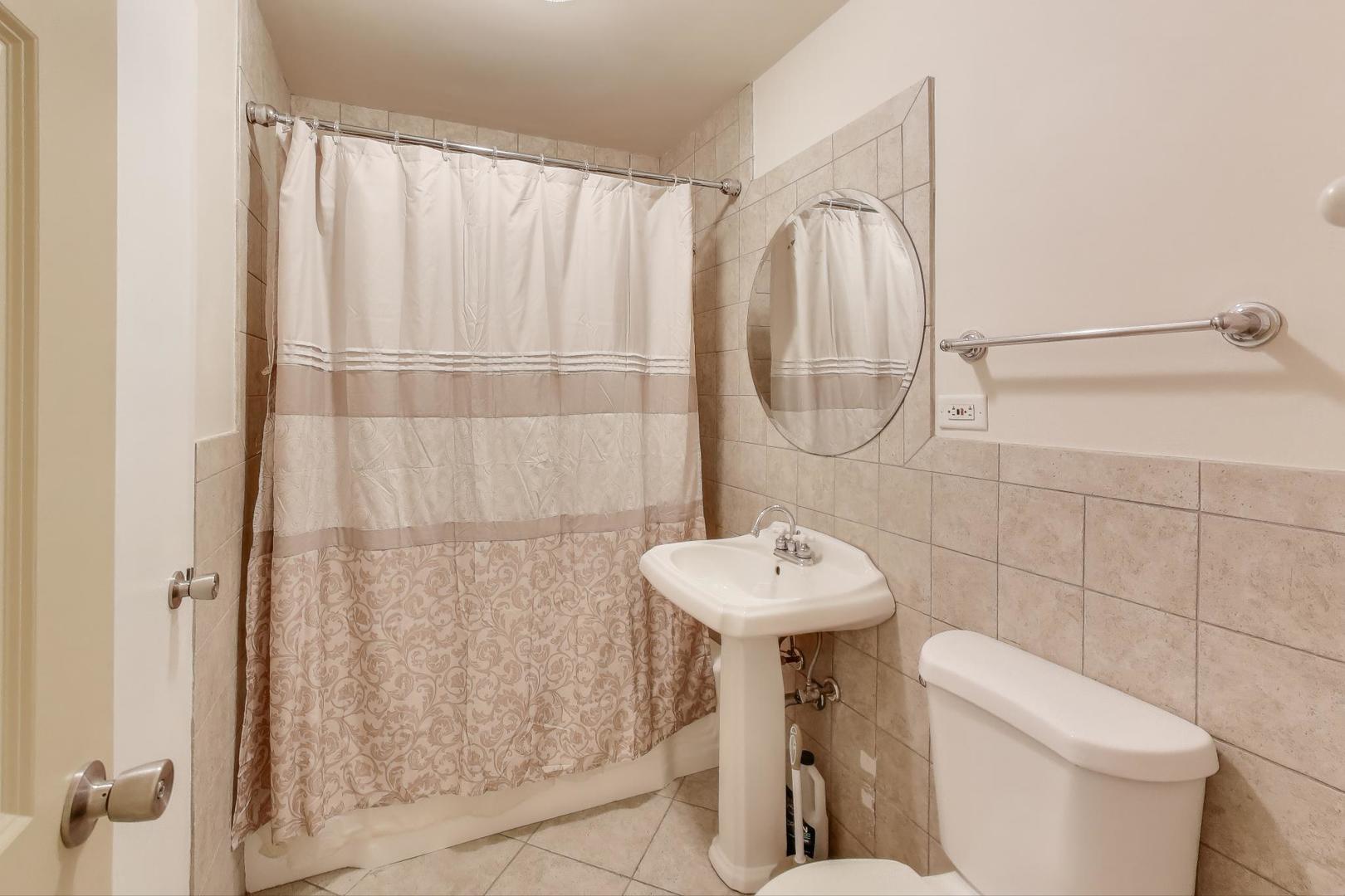 1516 Hinman Avenue, Unit 211 Evanston, IL 60201 - Photo 8 of 13 a bathroom with a sink a toilet and shower