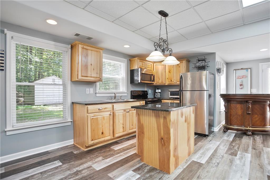 4185 Pool Road Winston, GA 30187 - Photo 45 of 57 a kitchen with stainless steel appliances granite countertop a refrigerator a sink dishwasher a stove and white countertops with wooden floor