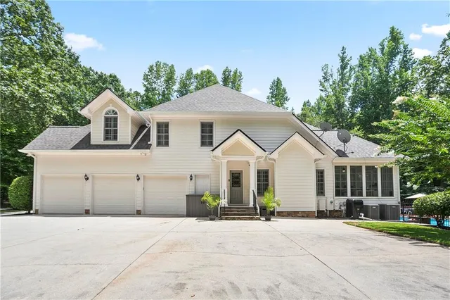 a front view of a house with a yard and trees