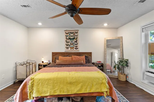 a bed sitting in a spacious bedroom next to a window