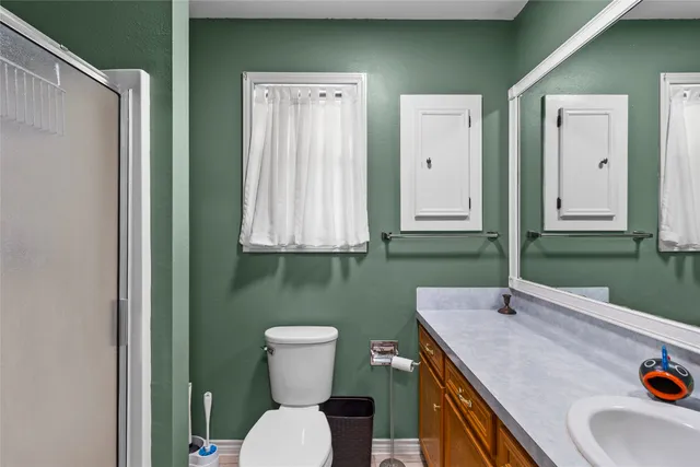 a bathroom with a toilet sink and mirror