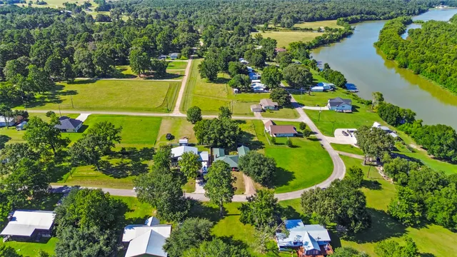 an aerial view of a house with a yard and lake view
