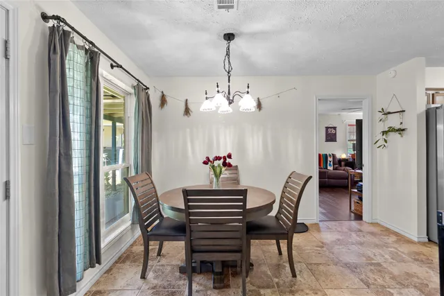 a view of a dining room with furniture and a chandelier