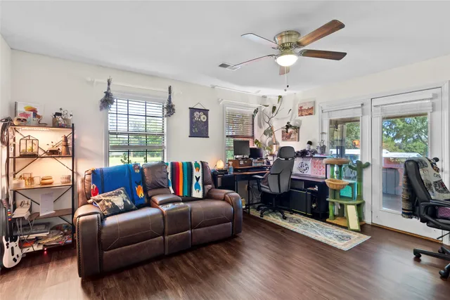 a living room with furniture ceiling fan and a window