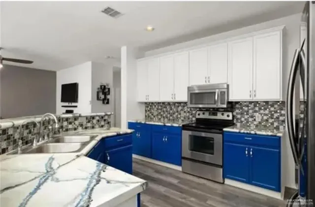 a kitchen with stainless steel appliances granite countertop a stove a sink and a microwave