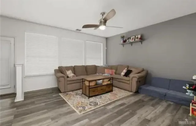 a living room with furniture and a ceiling fan