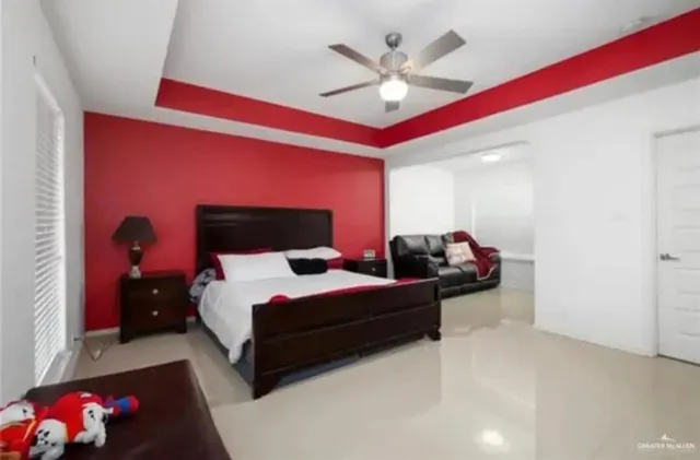 a spacious bedroom with a bed and a chandelier