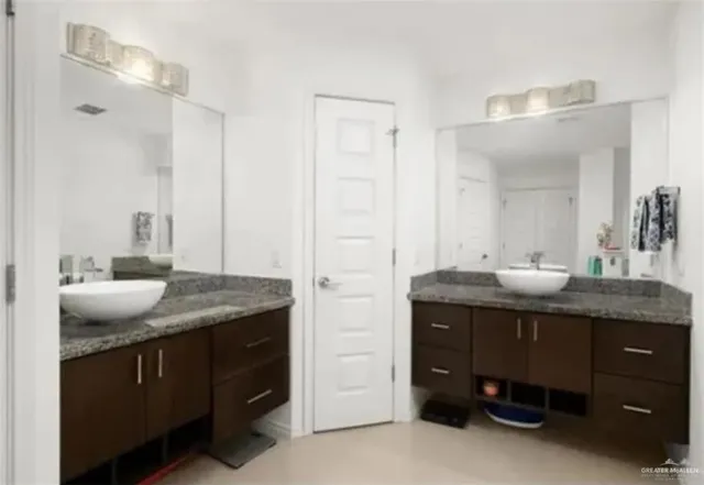 a bathroom with a granite countertop sink and a mirror