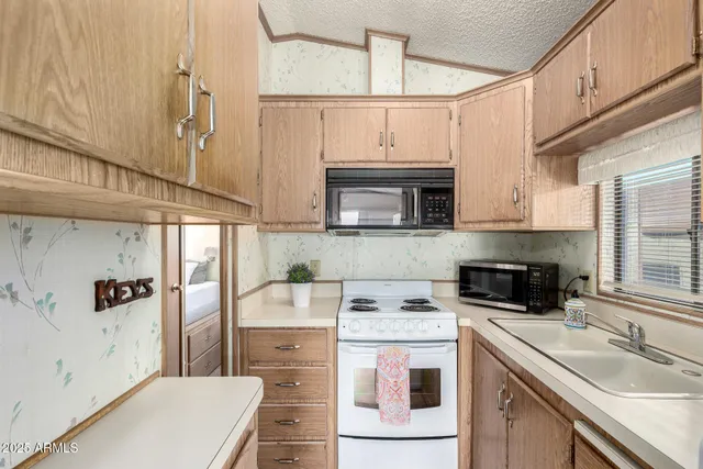 a kitchen with a sink a stove and cabinets
