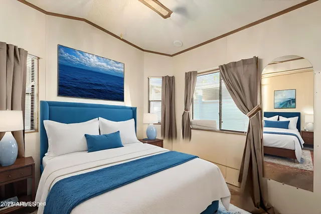 a bedroom with a bed and a large mirror on the dresser