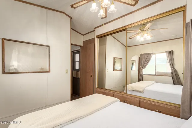 a bedroom with a large bed and a chandelier