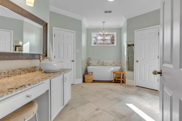a bathroom with a granite countertop sink and mirror with bathtub