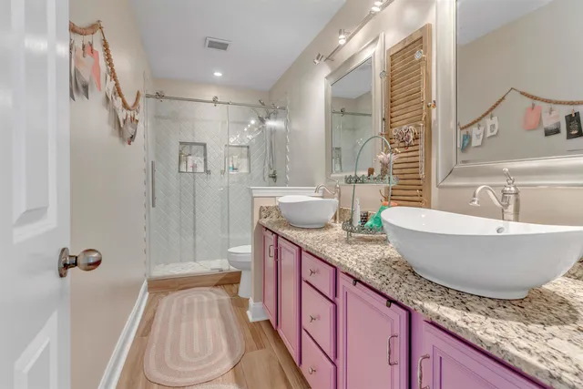 a spacious bathroom with a granite countertop sink a mirror a bathtub and shower