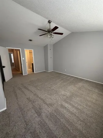 an empty room with windows and fan