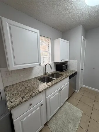 a kitchen with granite countertop a sink and a stove