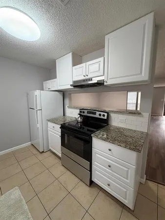 a kitchen with white cabinets and appliances
