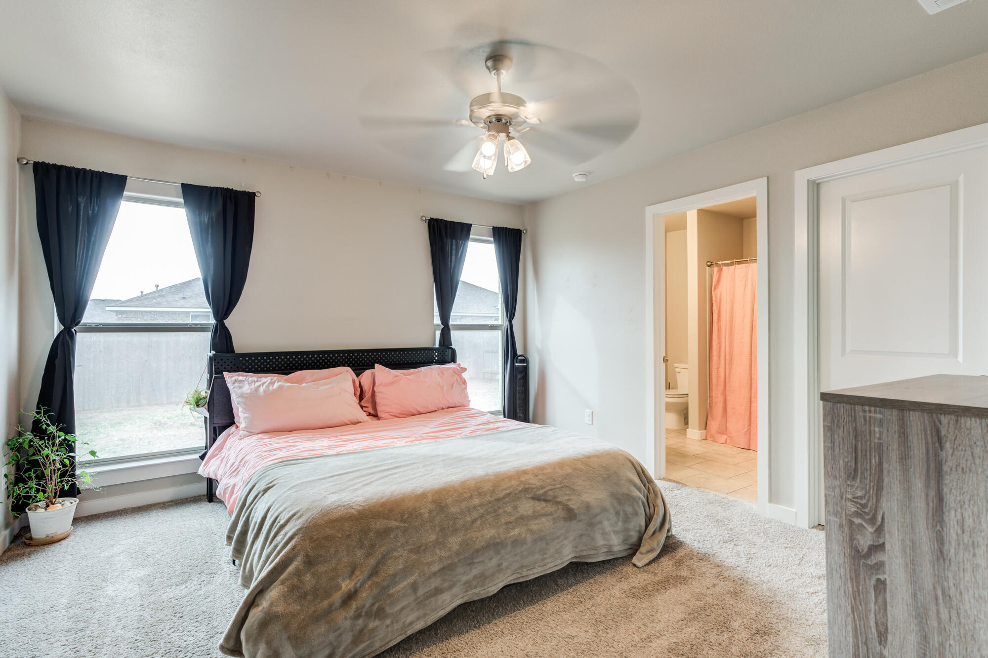 7429 31st Street Lubbock, TX 79407 - Photo 16 of 29 a bedroom with a large bed and a chandelier