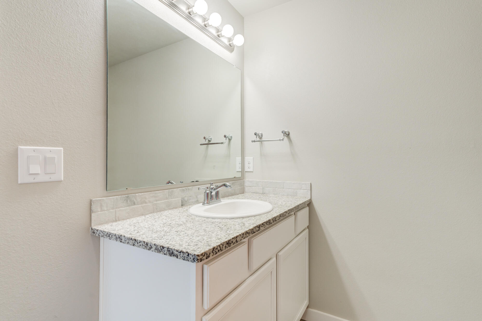 7429 31st Street Lubbock, TX 79407 - Photo 19 of 29 a bathroom with a granite countertop sink and a mirror