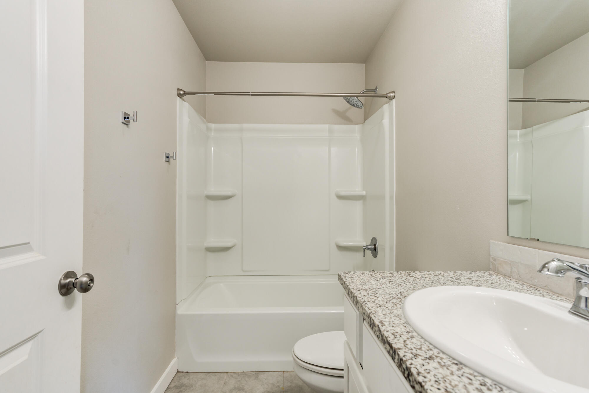 7429 31st Street Lubbock, TX 79407 - Photo 24 of 29 a bathroom with a granite countertop bathtub shower sink vanity and toilet